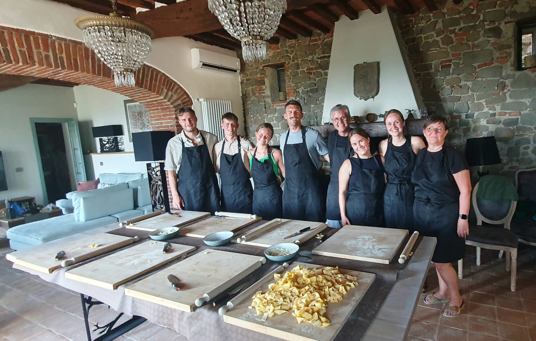 Cooking lesson group portrait around the worktables in Tuscany
